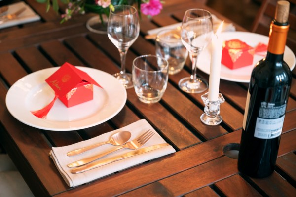 Cutlery plate knife and forks glass on table setting and flowers